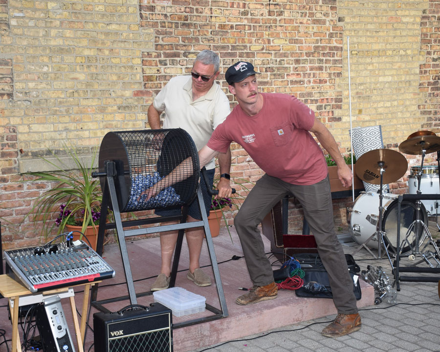 Ryan Ortmann pulls the Grand Prize number from the drum while Rotarian Al Schmit tends the drum.
